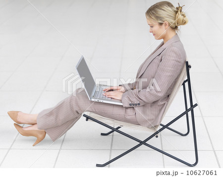 Businesswoman working on laptop in modern chair 10627061