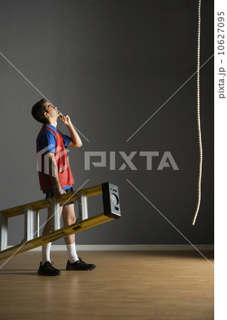Man holding ladder and looking at rope Man holding ladder and looking at rope 10627095