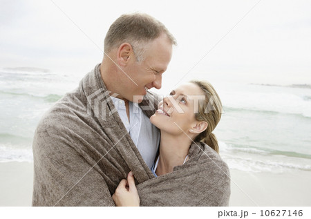 Embraced couple covered by blanket looking each other Embraced couple covered by blanket looking each other 10627146