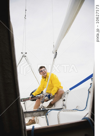 Man steering sailboat 10627573