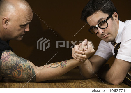 Nerdy man arm wrestling tattooed man Nerdy man arm wrestling tattooed man 10627714