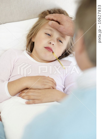 Grandfather tending granddaughter (10-11) lying in bed with thermometer in mouth Grandfather tending granddaughter (10-11) lying in bed with thermometer in mouth 10627833