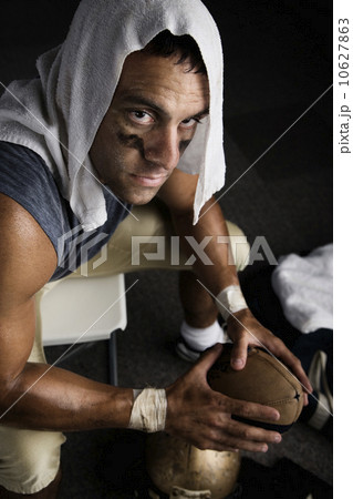 Football player with towel on head holding football 10627863