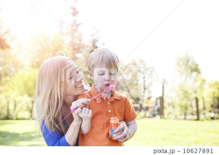Mother and son (2-3) blowing bubbles in park Mother and son (2-3) blowing bubbles in park 10627891