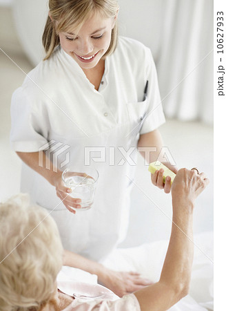 Nurse giving pill to senior woman Nurse giving pill to senior woman 10627933