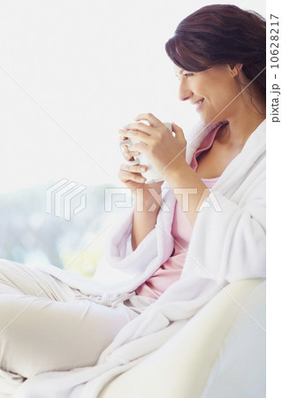 Woman in bathrobe drinking coffee 10628217