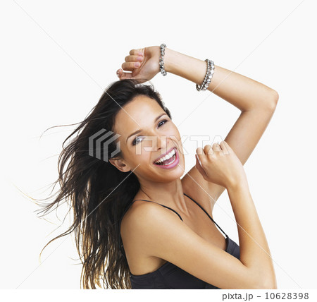 Studio Shot, Portrait of smiling young woman with raised arms 10628398