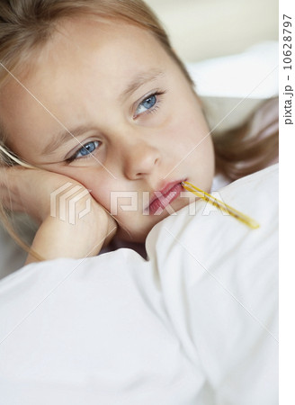 Girl (10-11) checking temperature with thermometer 10628797