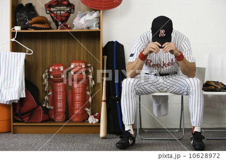 Baseball player sitting with head down in locker room Baseball player sitting with head down in locker room 10628972