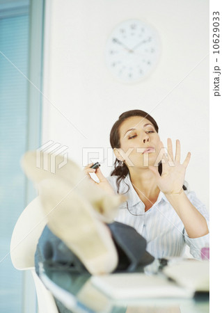 Woman painting fingernails at desk Woman painting fingernails at desk 10629033