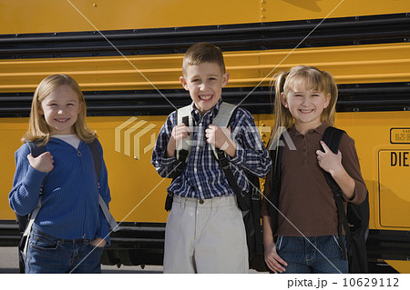 Children with back packs in front of school bus Children with back packs in front of school bus 10629112