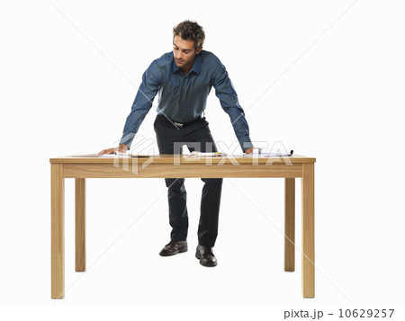 Portrait of smart business man standing with palms on table 10629257