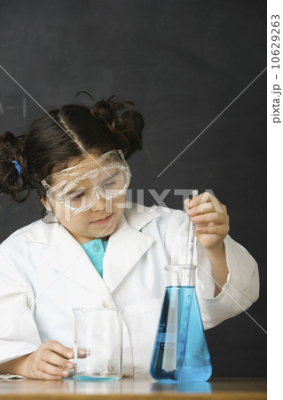 Girl measuring liquid in science class 10629263