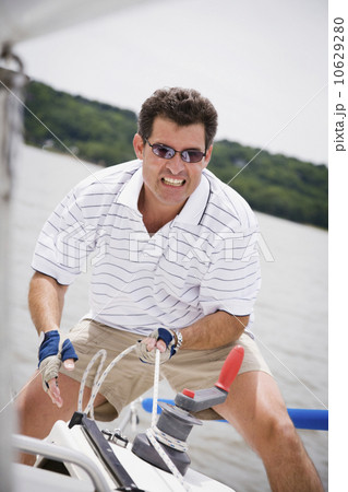 Man pulling rope on sailboat Man pulling rope on sailboat 10629280