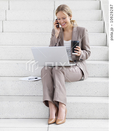 Businesswoman working on laptop and talking on cell phone Businesswoman working on laptop and talking on cell phone 10629287
