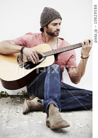 Musician playing guitar outdoors 10629588