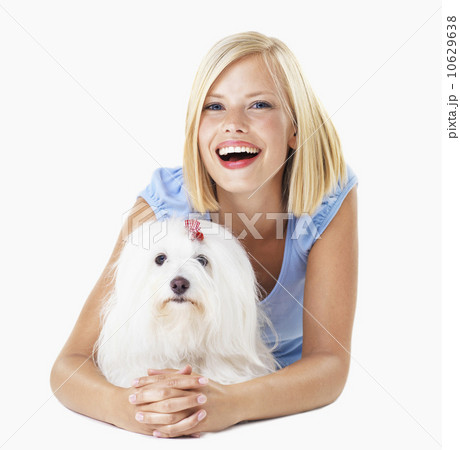 Studio Shot, Portrait of smiling young woman lying down with her dog Studio Shot, Portrait of smiling young woman lying down with her dog 10629638