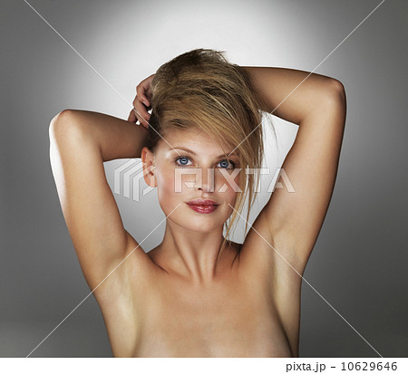 Seductive blond woman with her hands behind her head 10629646