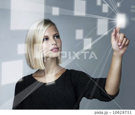 Young woman using futuristic touchscreen, studio shot Young woman using futuristic touchscreen, studio shot 10629731