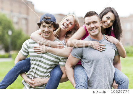 Portrait of two couples piggybacking on campus 10629774