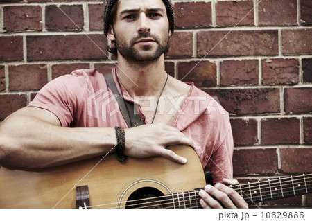 Portrait of musician against brick wall 10629886