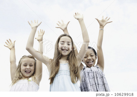 Three young girls with their arms raised 10629918