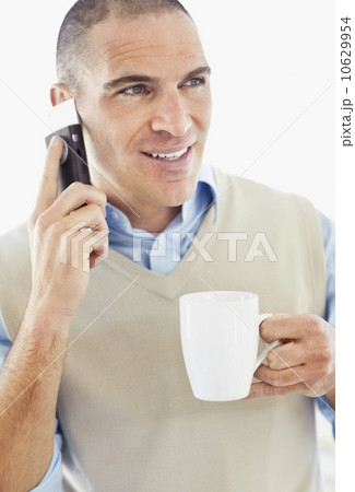 Office worker holding mobile phone in one hand and cup in another 10629954