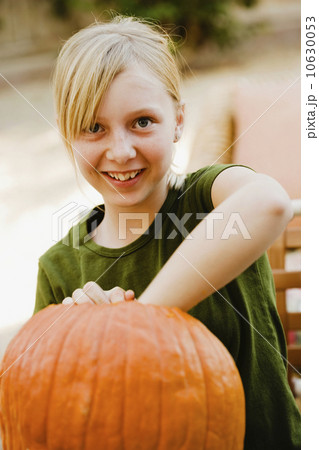 Girl scooping out pumpkin Girl scooping out pumpkin 10630053