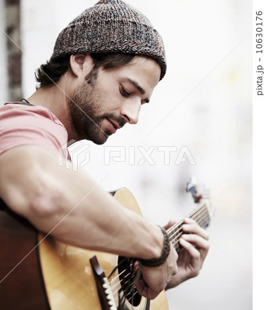 Portrait of musician playing guitar outdoors 10630176