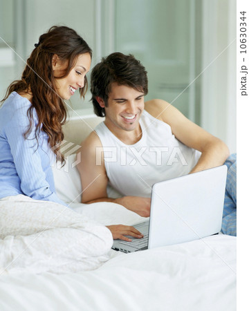 South Africa, Young couple using laptop while sitting on bed South Africa, Young couple using laptop while sitting on bed 10630344