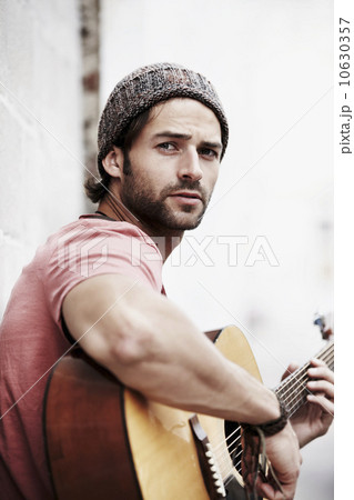 Portrait of musician playing guitar outdoors 10630357
