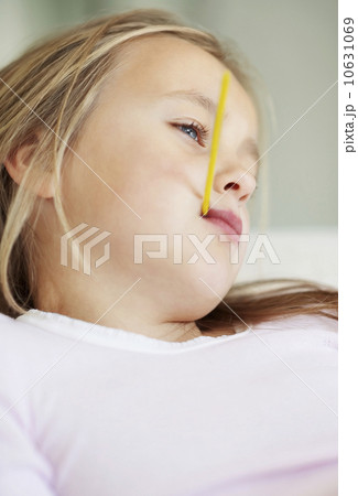 Girl (10-11) checking temperature with thermometer Girl (10-11) checking temperature with thermometer 10631069