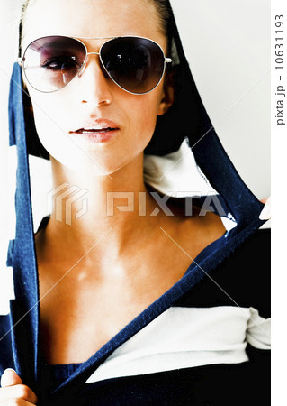 Portrait of young woman wearing striped blouse and sunglasses 10631193