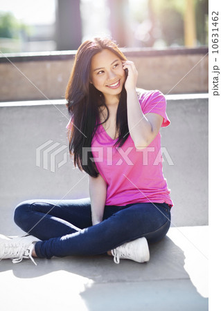 Young chinese woman using mobile phone outdoors 10631462
