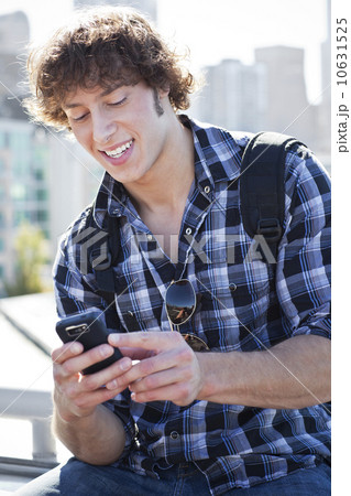 USA, Washington, Seattle, Man text messaging outdoors 10631525