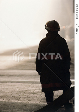 Silhouette of fireman looking at smoke in distance 10631548