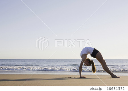 Woman doing yoga on beach 10631572