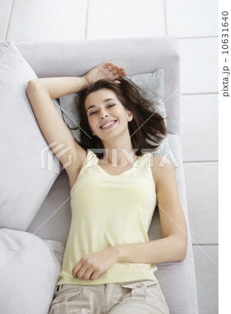 Cheerful brunette woman relaxing on couch 10631640