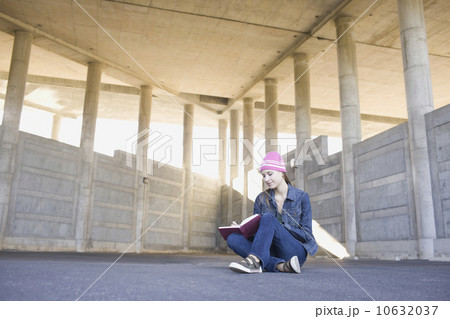 Young woman reading in urban setting 10632037