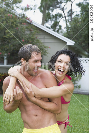 Couple in bathing suits hugging in backyard 10632054