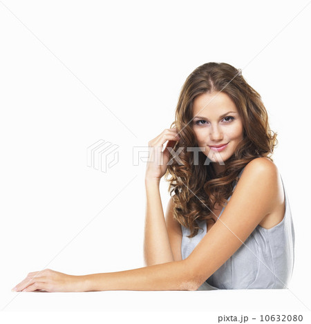 Studio portrait of young woman sitting at table and smiling 10632080