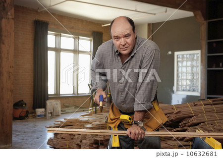 Man cutting piece of plank 10632681