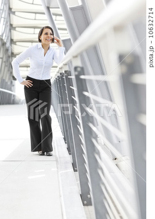 Young businesswoman on walkway, using cell phone 10632714