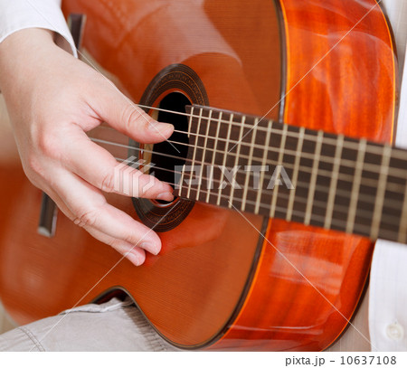 man plays on typical acoustic guitar man plays on typical acoustic guitar 10637108