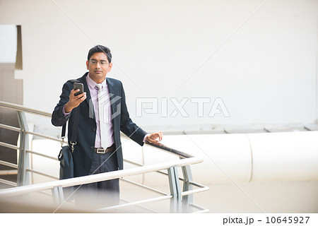 handsome indian business executive working on smart phone in off 10645927
