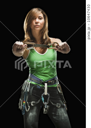Studio shot of a female climber holding carabiners 10647430