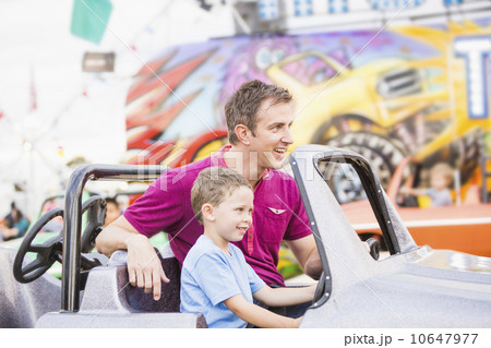 Father with son (4-5) driving toy car in amusement park Father with son (4-5) driving toy car in amusement park 10647977