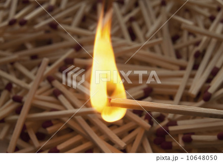 Lit match on top of a pile of wooden matches 10648050