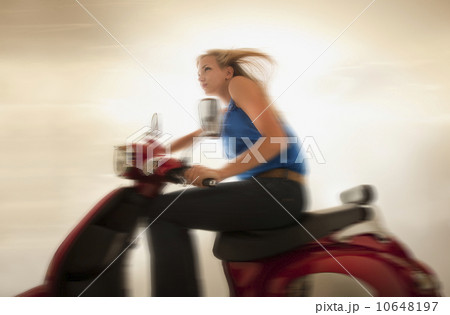 Young girl (16-17) riding scooter 10648197