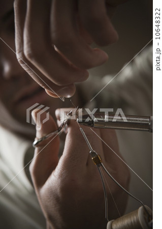 Man repairing fly fishing hook Man repairing fly fishing hook 10648322